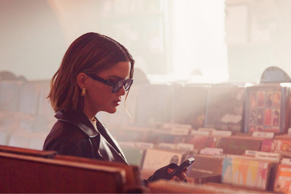 Maren Morris checking her phone in a record store