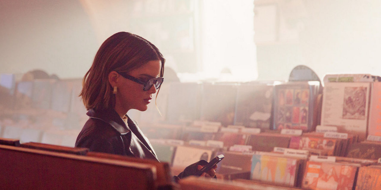 Maren Morris checking her phone in a record store