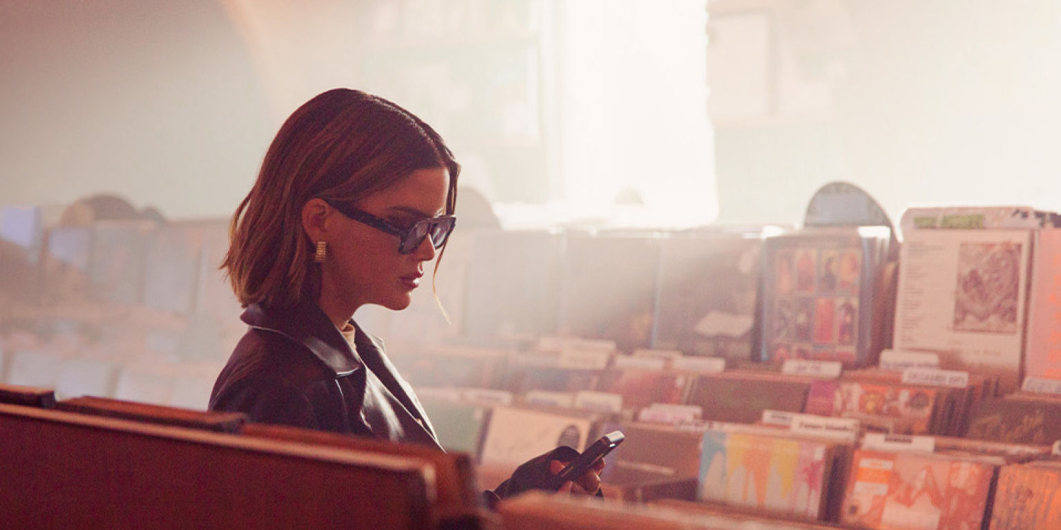 Maren Morris checking her phone in a record store