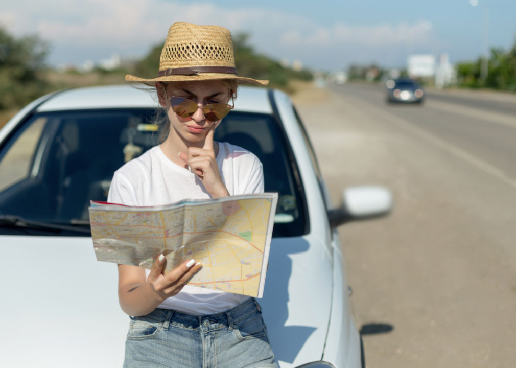 Woman on the side of a road looking at an app