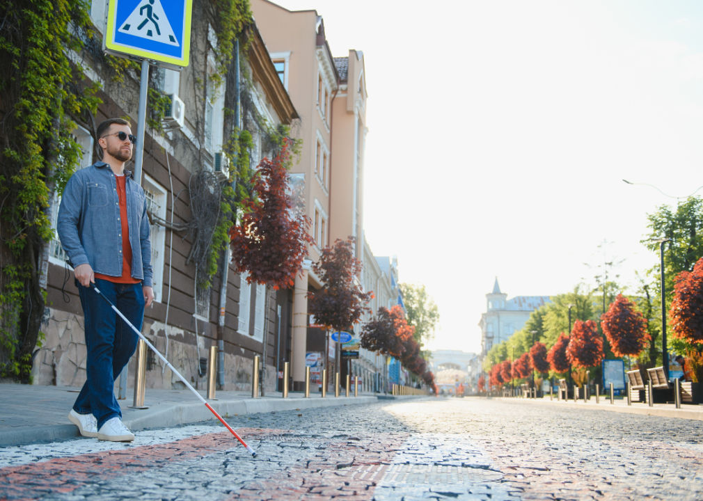 A vision-impaired man crossing the street